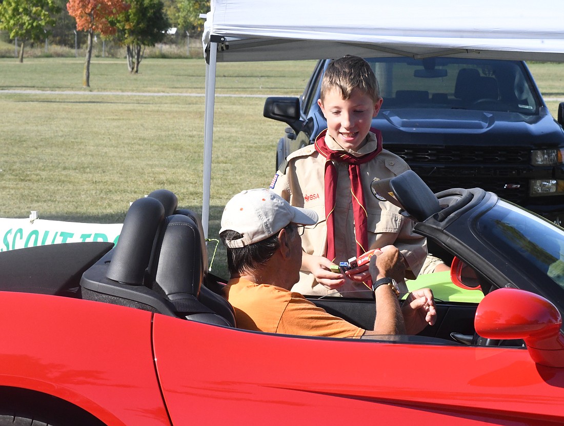 Luke Jellison, 11, of BSA Troop 202 of Portland offers a selection of gum to John Coldren during Saturday’s Jay County Cancer Society Cancer Cruise and Carnival at Jay County Fairgrounds. (The Commercial Review/Ray Cooney)