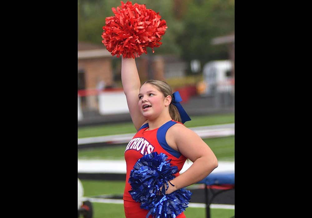 Emery Barton of the Jay County High School cheerleading squad performs during the fight song prior to the Patriots’ football game at Bluffton on Friday. (The Commercial Review/Andrew Balko)