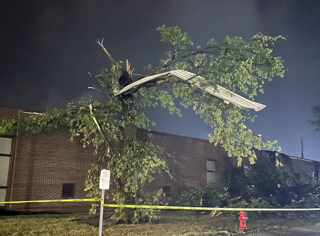 A piece of metal hangs in a snapped tree along the front of Jay County Junior-Senior High School on Sunday evening. A severe storm caused significant damage to the junior high area of the building and the IMC (library). Jay School Corporation has canceled classes for Monday, Sept. 23. (The Commercial Review/Ray Cooney)