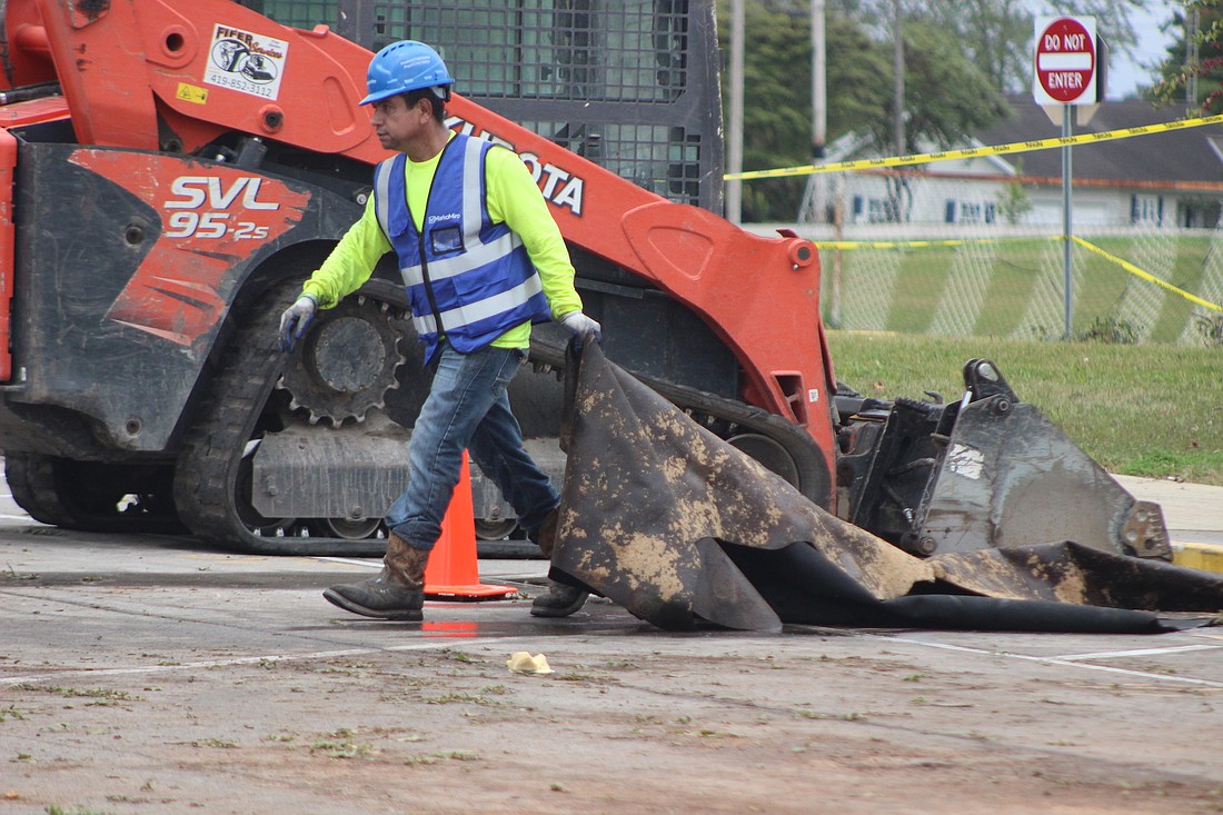 A construction worker drags debris at Jay County Junior-Senior High School amid cleanup efforts Tuesday morning following the Sunday evening tornado that caused extensive damage to the junior high and IMC (library) area of the building. Jay School Corporation superintendent said this morning that cleaning and restoration firm Servpro has about 50 employees on site working on putting a tarp over the roof, removing water and other liquids from inside and cleaning. (The Commercial Review/Bailey Cline)