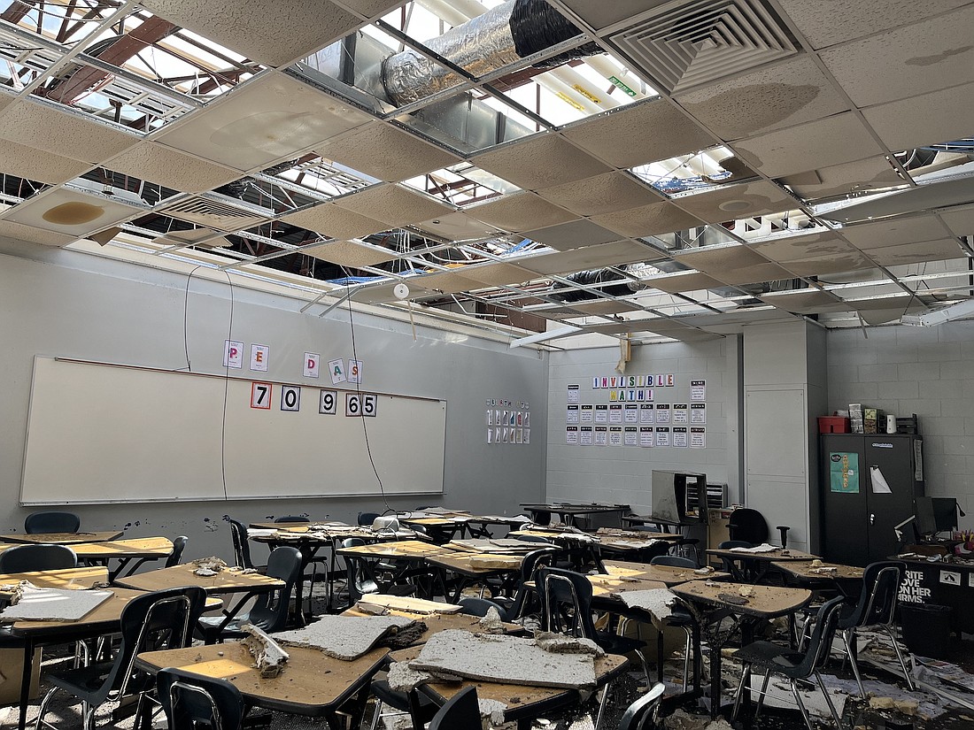 Clean-up efforts continue at Jay County Junior-Senior High School following a Sunday tornado that caused significant damage. Pictured, debris covers desks in a classroom along the south side of the building with the ceiling still open after the storm ripped holes in the roof. (The Commercial Review/Ray Cooney)