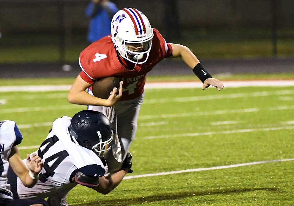 Woodlan High School’s Emerson Spieth drags down Jay County quarterback Sean Bailey during the second half of the Patriots’ 21-0 homecoming loss. The Warriors sacked Bailey six times and had seven other tackles for a loss. (The Commercial Review/Ray Cooney)