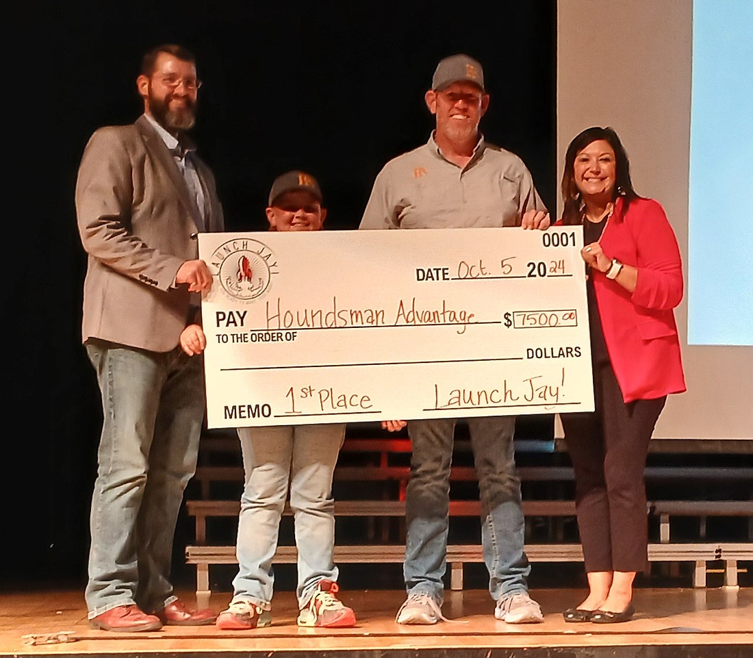 Matt Lingo of Houndsman Advantage receives his check for winning the Launch Jay! business pitch competition Saturday evening alongside his son Drew at Jay County Junior-Senior High School. Presenting the check are Travis Richards (left) of Jay County Development Corporation and Tabby Sprunger (right) of Jay County Chamber of Commerce. (Photo provided)