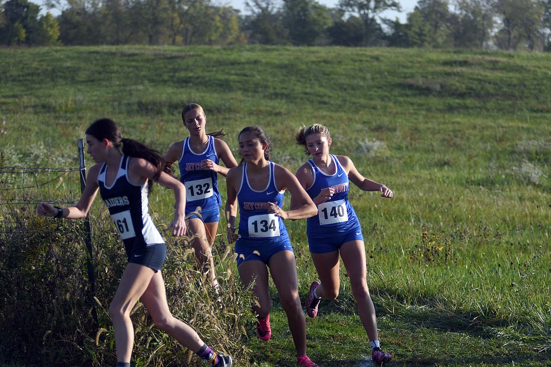 Natalie Carreno (134), Alexis Sibray (140) and Lizzy Brunswick (132) all take a sharp right turn on Saturday at the Winchester Invitational, that the Jay County High School girls cross country team won 28 points. All three of the pictured Patriots placed in the top 15, with Sibray finishing the highest at eighth. (The Commercial Review/Andrew Balko)