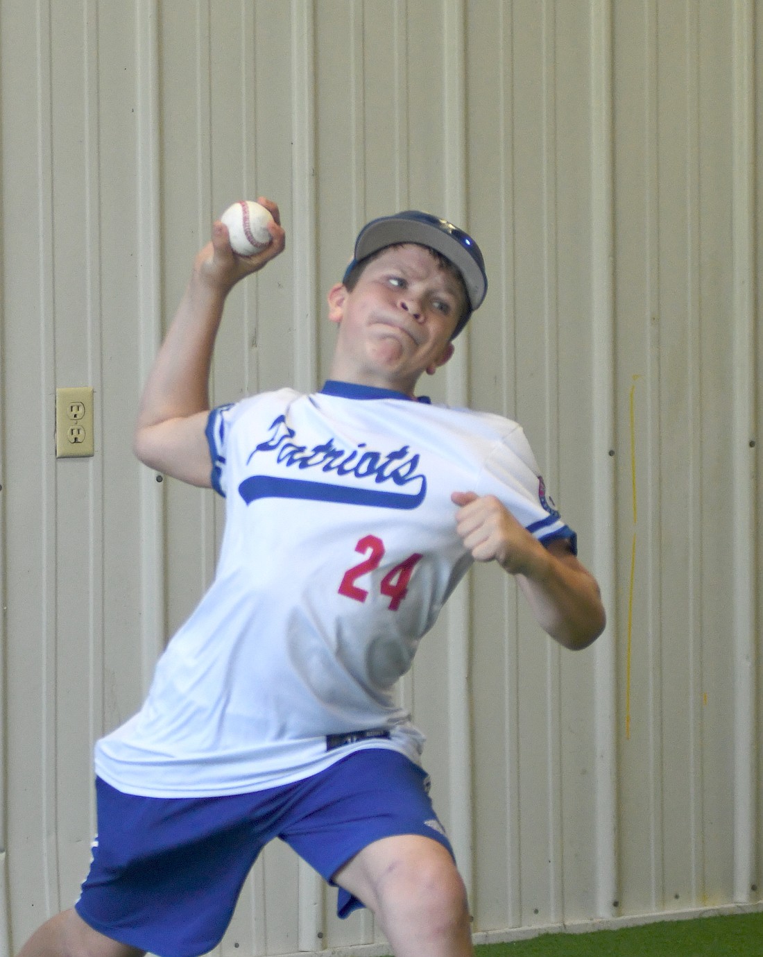 Sawyer Smitley winds up to throw a ball into the net to get a read on his velocity Saturday at the Jay County Baseball Club’s grand opening of The Clubhouse. The indoor facility has been in the works since 2023 and is officially open for use. (The Commercial Review/Andrew Balko)