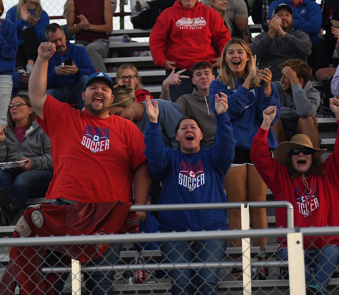 Brion Kahn and Caressa Runyon-Kahn cheer after Dylan Marentes’ goal put the Jay County High School boys soccer team up 4-1 in the sectional semifinal game on Wednesday at Eastbrook. Marentes scored two goals and assisted another to lift the Patriots past the Delta Eagles and earn them a spot in Saturday’s sectional championship against the host Panthers. (The Commercial Review/Andrew Balko)