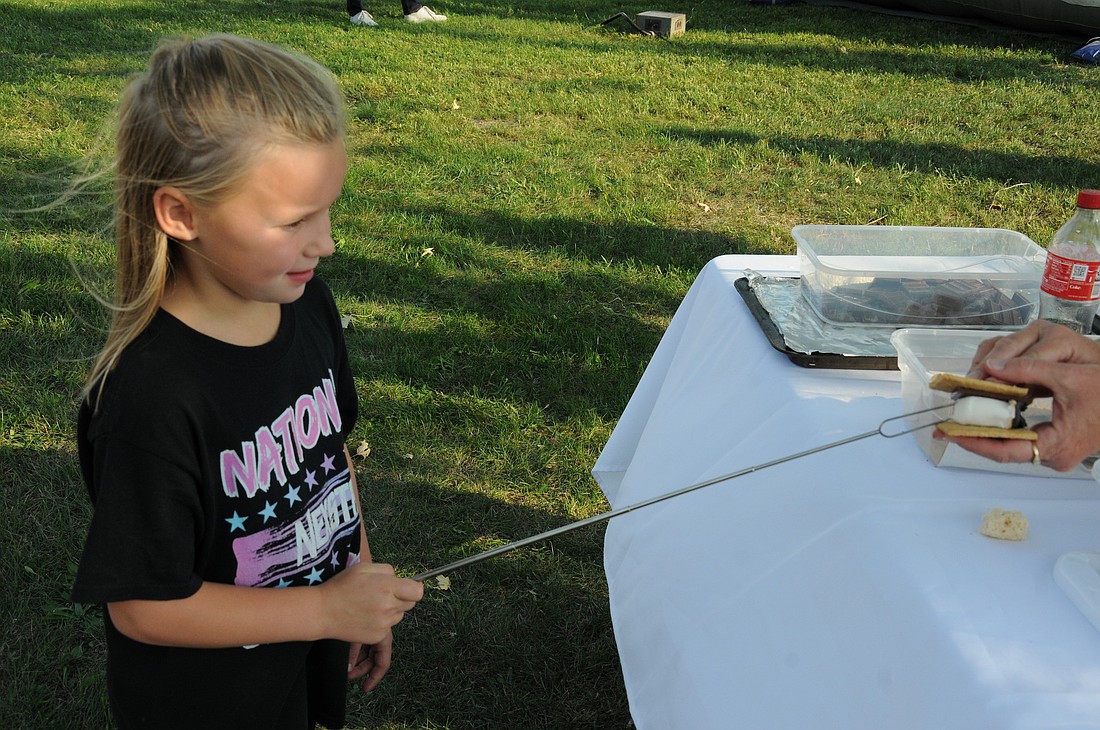 Brooklyn Herriford, 6, gets her marshmallow topped off at the smores table during the Bryant Chili and Fun Night Saturday sponsored by the Town of Bryant and the Jay County Trails Club. (The Commercial Review/Bailey Cline)