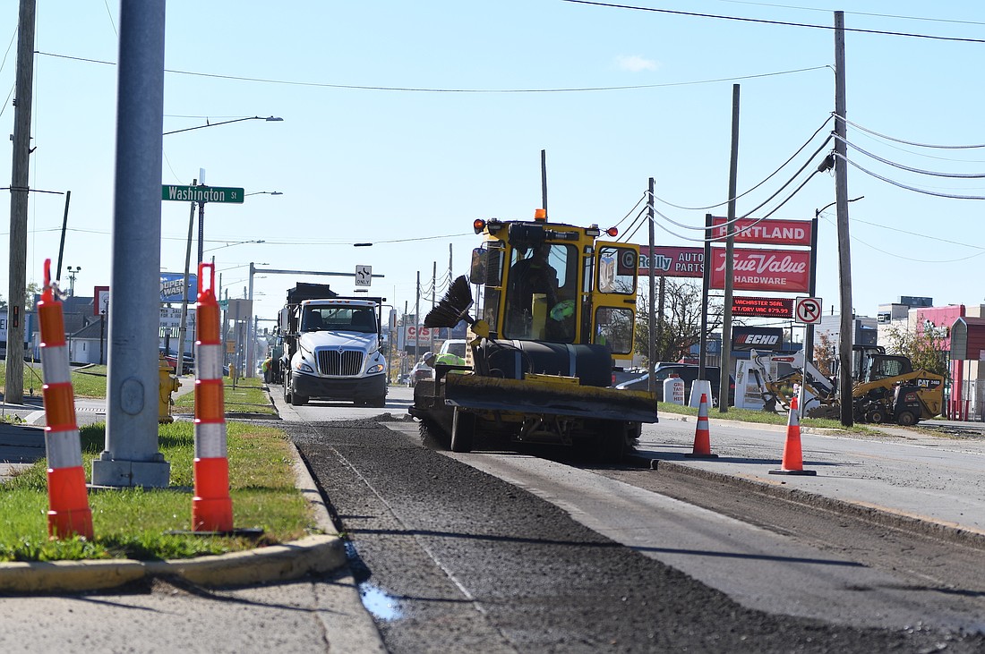 Construction crews work on the east side of Meridian Street (U.S. 27) at its intersection with Washington Street in Portland on Thursday morning. The work is part of an ongoing Indiana Department of Transportation project that involves paving U.S. 27 through the city, upgrading sidewalk ramps and installing new traffic signals. Work is expected to continue into November. (The Commercial Review/Ray Cooney)