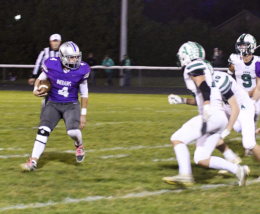 Fort Recovery High School’s Caden Grisez looks for a crease between two Anna Rocket defenders during the Indians’ 49-6 loss to Anna on Friday. Fort Recovery has lost three out of its last four and is now 2-7 on the season. (The Commercial Review/Will Cash)