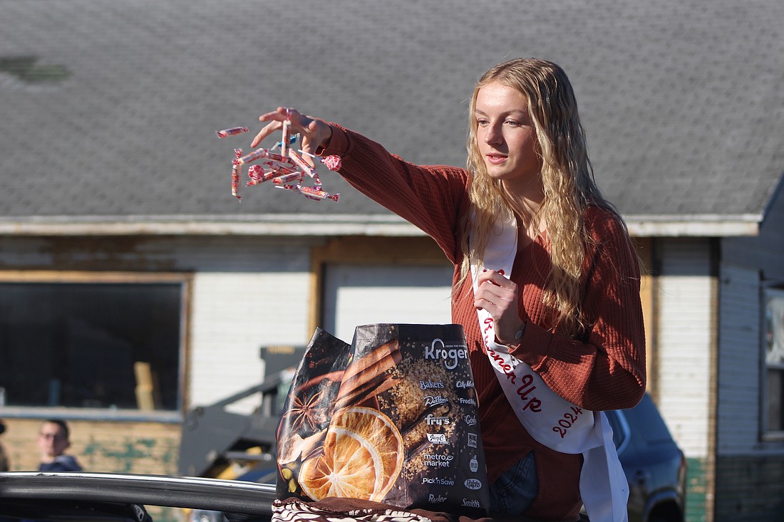 Makinsey Murphy, second runner-up of the 2024 Miss Jay County Fair Queen Pageant, tosses candy to paradegoers Saturday morning along Union Street (Indiana 1) in Pennville. The parade marked the beginning of Pennville Pumpkin Festival in the park. (the Commercial Review/Bailey Cline)