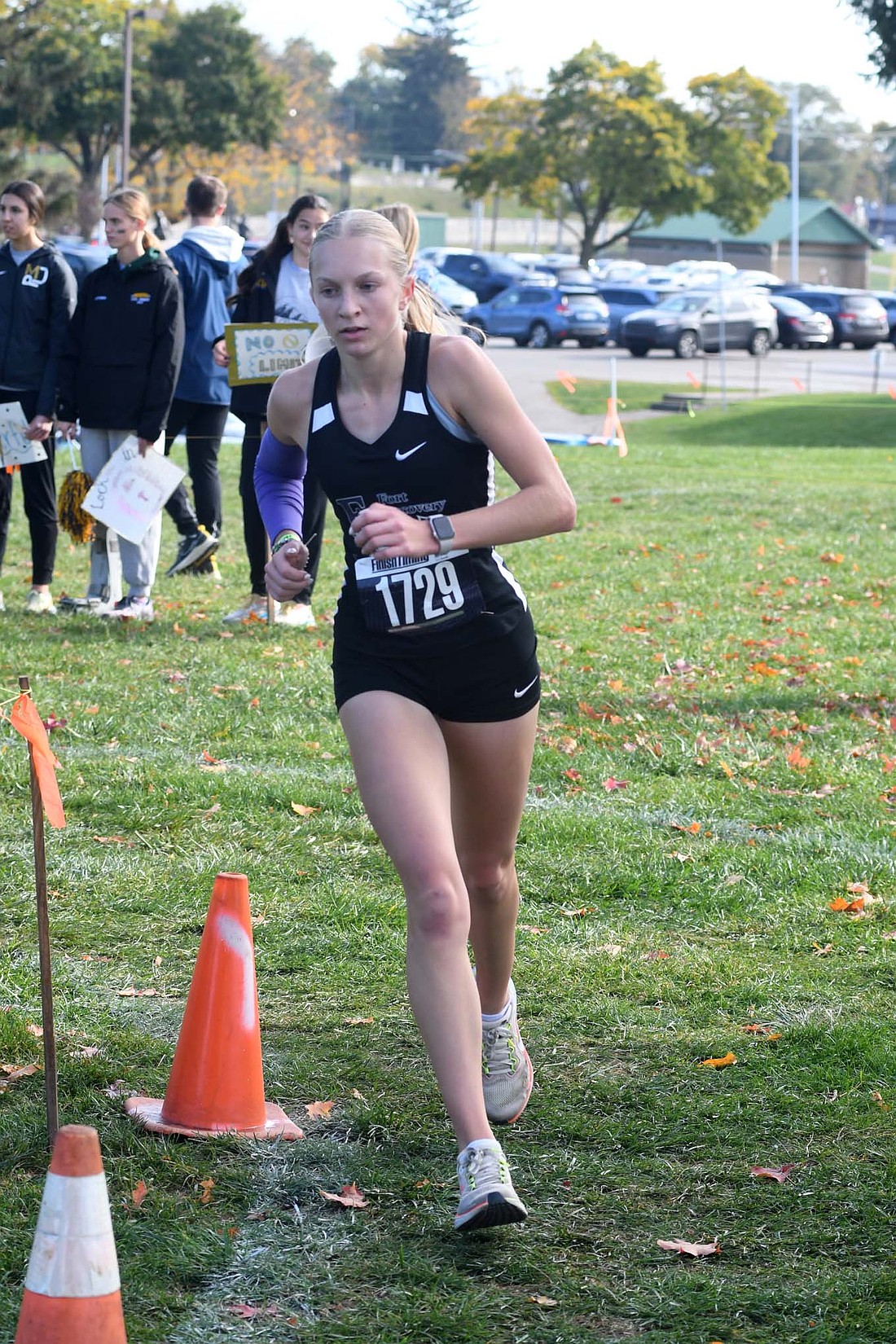 The Fort Recovery High School cross country team’s season came to a close Saturday at the OHSAA Division III Regional meet at Troy. Pictured above, senior Anna Roessner races near the part of the course that takes the form of a horseshoe in the third mile. Below, Reese Diller sprints alongside Russia’s Quinn Hoying in an attempt to reach the finish line first. (The Commercial Review/Andrew Balko)