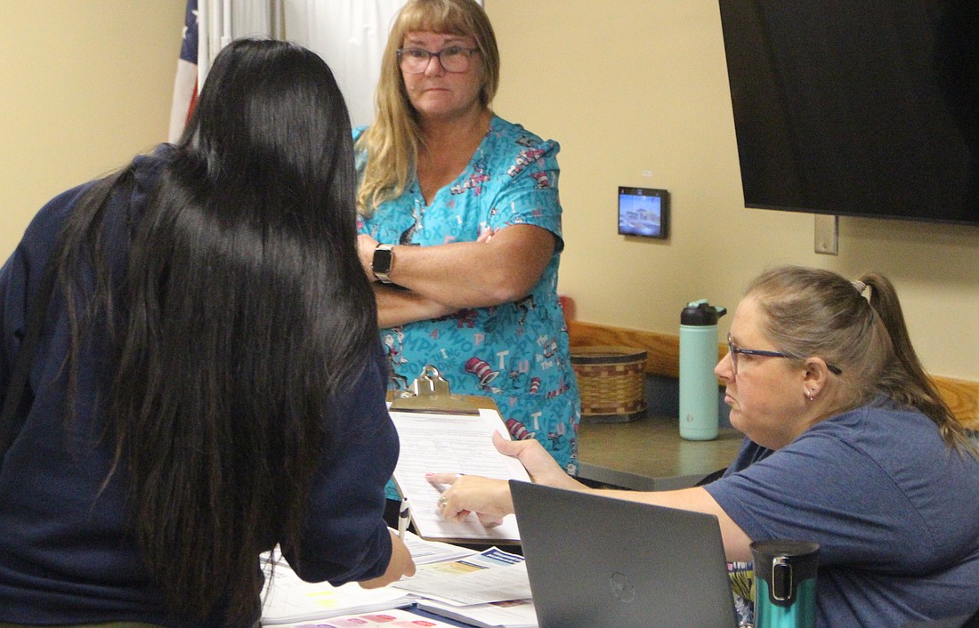 Nurses hand a woman paperwork to fill out during the Hispanic Health Fair at IU Health Jay on Saturday. Dozens of people visited the hospital Saturday morning for the health fair, which offered health screenings, informational booths, access to mental health care, breakfast and other resources. Event organizer and Progressive Del Toro Office Products owner Adolfo Solis noted the language barrier can present a challenge for Hispanics seeking health care. “(Today) worked out good, and we’re looking forward to the next year,” he said.  (The Commercial Review/Bailey Cline)