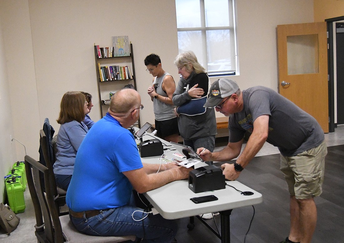 Poll workers assist voters with check in Tuesday morning at Jay Community Center in Portland. There was a consistent flow of traffic at the polling site to vote in this year’s election, which includes races ranging from county commissioner to Indiana governor to president. (The Commercial Review/Ray Cooney)