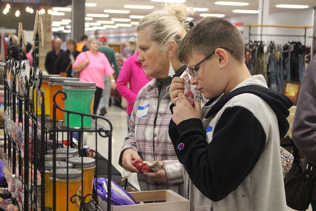 Tyler Henline, 15, right, and Beth Burd of Auglaize County, Ohio, check out wax melts from MerryWood Candles of Muncie during the Delt’s Craft Show on Saturday at Jay County High School. (The Commercial Review/Bailey Cline)