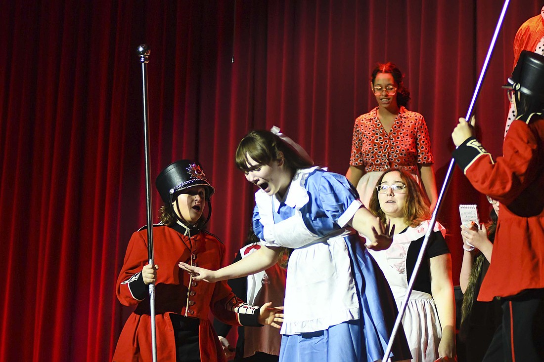 Alice (Alison McGraw) screams in frustration as she breaks away from the soldiers who are holding her at the conclusion of her trial during Tuesday’s rehearsal for Jay County Junior-Senior High School’s production of “Alice in Wonderland: Down the Rabbit Hole,” an adaptation of the classic tale. The show is described as a contemporary twist on the 1865 Lewis Carroll novel “Alice’s Adventures in Wonderland.” (The Commercial Review/Ray Cooney)