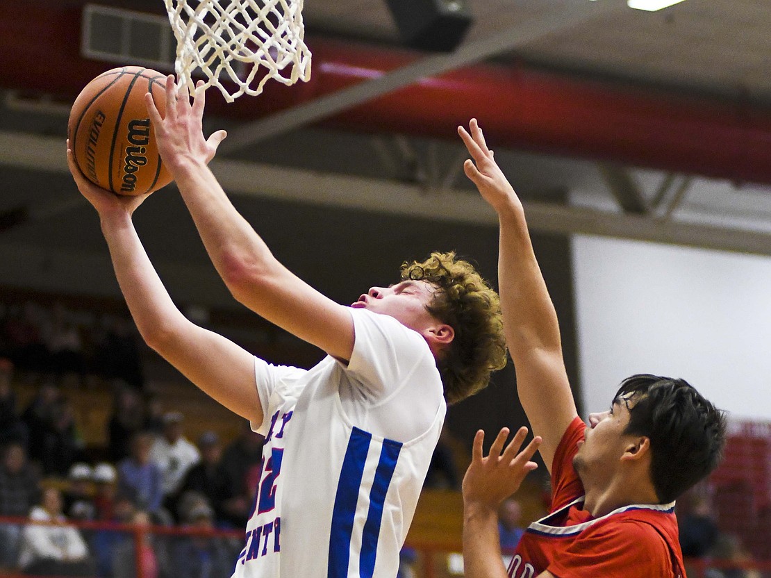 Tucker Griffin of Jay County High School goes to the basket in front of Elwood's Blaise Jones during the Patriots' 42-23 season-opening win Tuesday. Griffin, a senior transfer from New Castle, shared the team high of 10 points with junior Gradin Swoveland. (The Commercial Review/Ray Cooney)