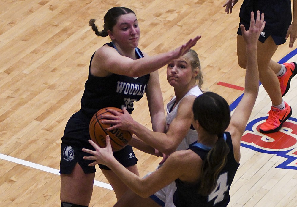 Jay County High School sophomore Hallie Schwieterman fights to get a shot up between McKenna Goble (left) and Alyssa Anderson (right) of Woodlan during the second quarter of the Patriots’ 52-46 loss Friday to the Warriors. Schwieterman scored a career-high 30 points for JCHS, but no one else on the squad had more than five points. (The Commercial Review/Ray Cooney)