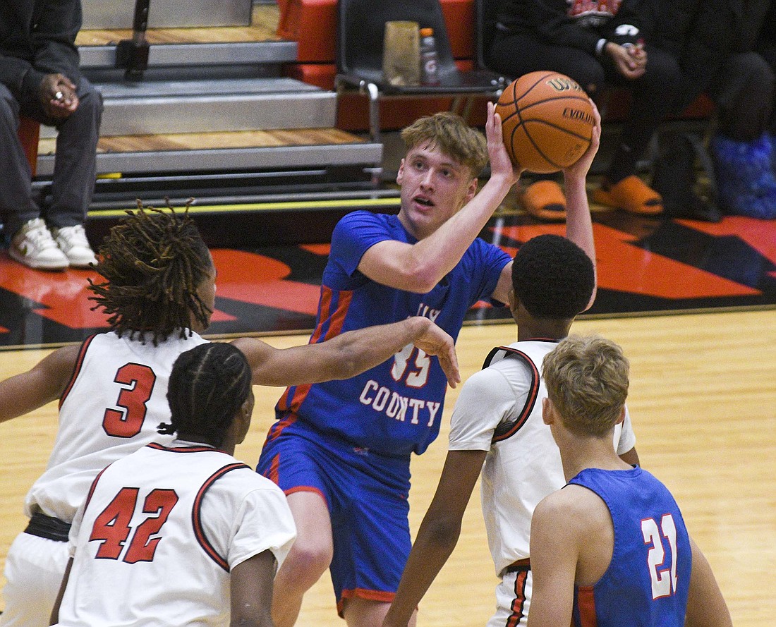 Jay County High School’s Gradin Swoveland pulls up for a one-legged jumper against Richmond’s Mason Carpenter. Swoveland scored a team-high 14 points in the 43-36 loss on Saturday at Richmond. (The Commercial Review/Will Cash)