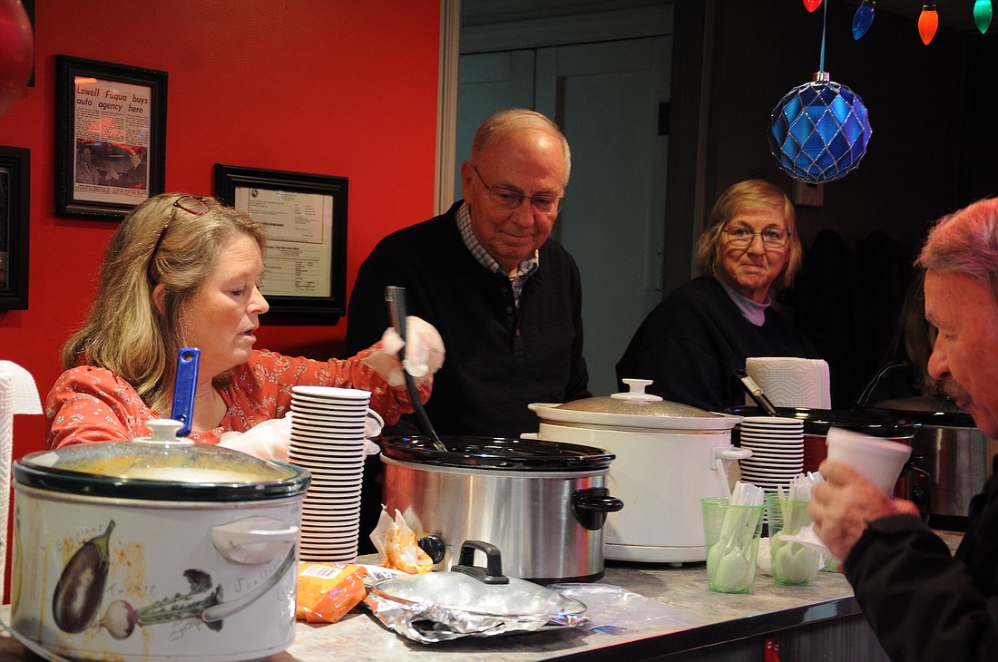 Lori McClain and Larry Spade from Mt. Tabor/Sugar Grove Church pass out hot dogs and soup to guests at Glass Capital Chrysler, Dodge, Jeep, and Ram Monday during Dunkirk's annual Feel the Warmth of Christmas celebration. (The Commercial Review/Samantha Murock)