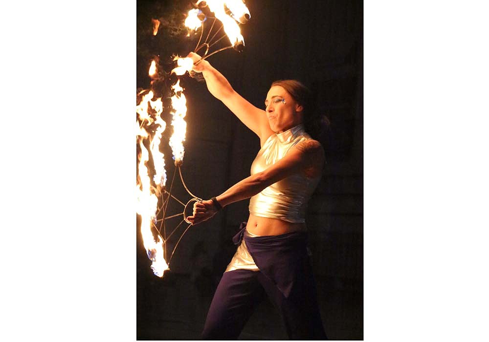 A performer with Celestial Circus Productions of Dayton, Ohio, twirls batons on fire Friday at Jay Community Center in Portland. Jay Community Center hosted its family fun night Friday, offering free pizza, pop and a show in exchange for good will donations of non-perishable food items. (The Commercial Review/Bailey Cline)