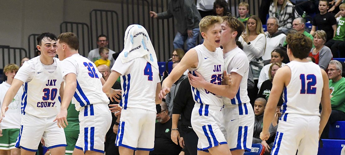 The Jay County High School boys basketball team celebrates following its 58-56 double-overtime victory against New Castle Saturday. (The Commercial Review/Andrew Balko)