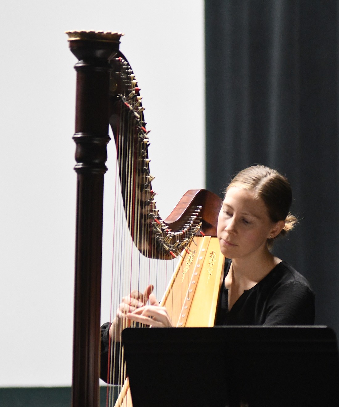 Kathryn Fenstermacher plays the harp during a rendition of “As With Gladness Men of Old” on Wednesday evening during the Eastern Breeze flute ensemble and harp recital at Arts Place. The recital also featured “God Rest Ye Merry, Gentlemen” and “Silent Night.” (The Commercial Review/Ray Cooney)