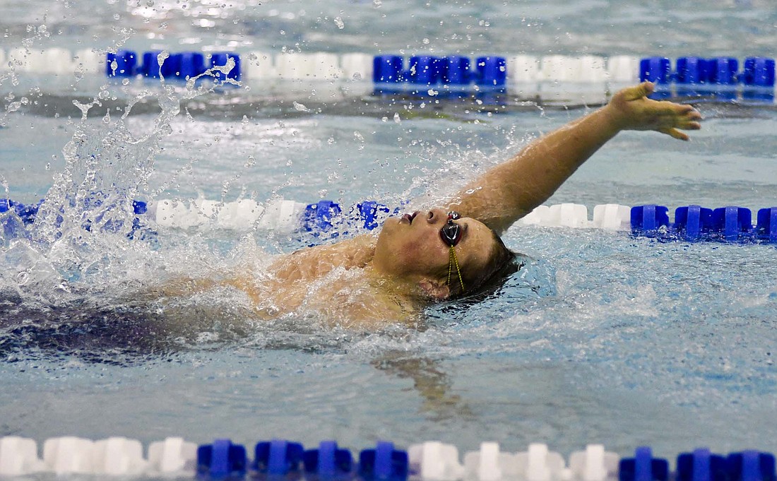 Matthew Fisher of the Jay County High School boys swim team competes in the 100-yard backstroke on Tuesday. Fisher finished second in the event, as the Patriots fell to sectional-foe Delta 161-104. (The Commercial Review/Ray Cooney)