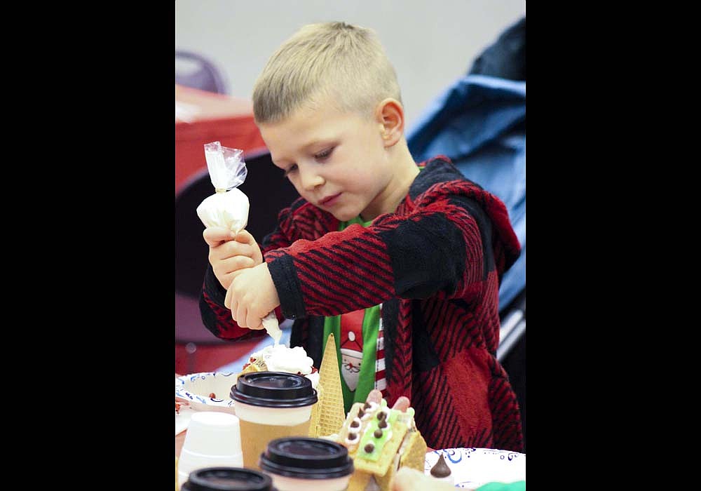 Hudson May, 5, puts icing on his gingerbread house Tuesday at Jay County Public Library. May and his siblings decorated sweet treats during the library’s free gingerbread event. (The Commercial Review/Bailey Cline)