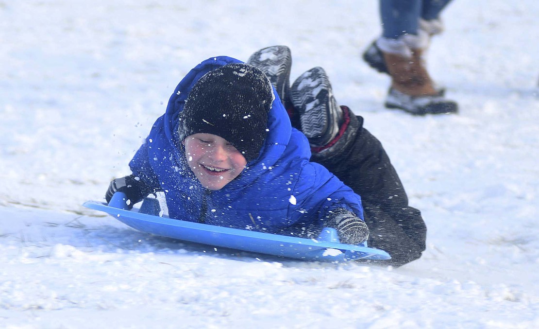 Snow sprays in the face of Phynox Storie while sledding with friends Jan. 18 at Hudson Family Park in Portland. (The Commercial Review/Ray Cooney)