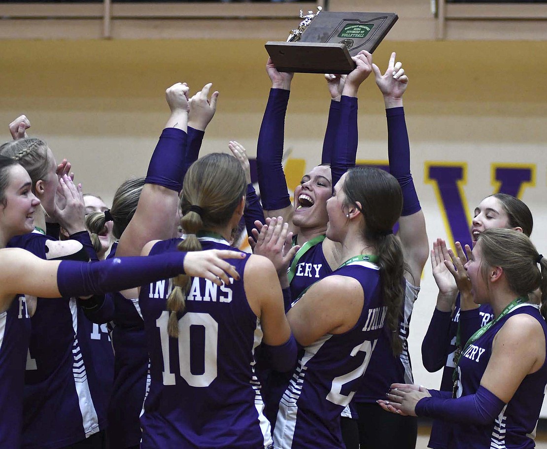 At right, Fort Recovery High School’s Kayla Heitkamp holds up the OHSAA Division VI Southwest 2 District Championship trophy while her teammates celebrate around her on Oct. 26 at Butler. The Indians swept Miami Valley Christian Academy to clinch their first regional appearance since 2020. (The Commercial Review/Andrew Balko)