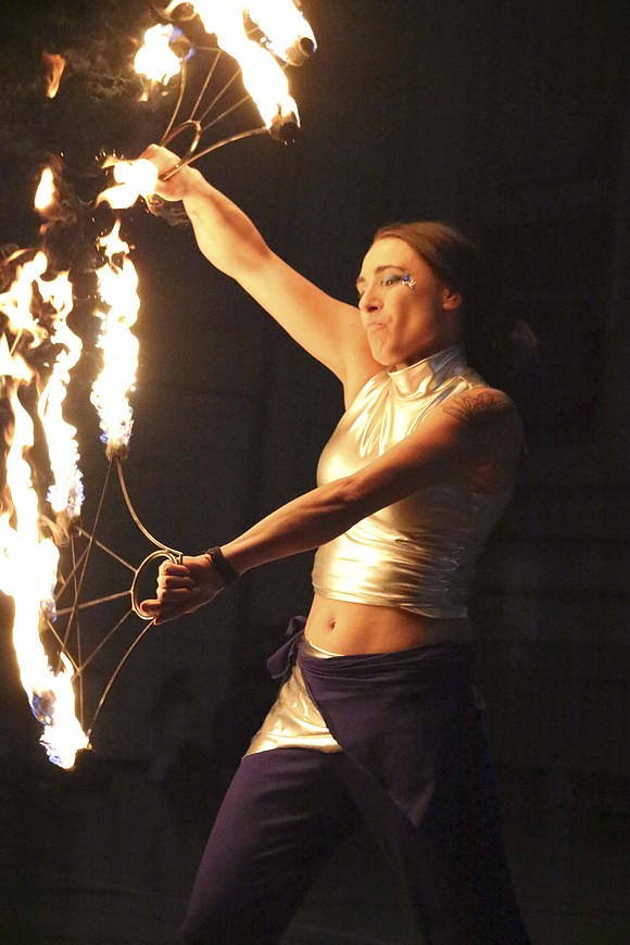 A performer with Celestial Circus Productions of Dayton, Ohio, twirls batons on fire Dec. 13 at Jay Community Center in Portland. (The Commercial Review/Bailey Cline)