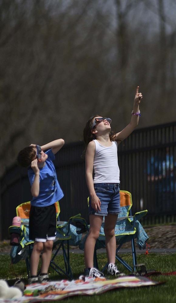 Quinn Klaassen, 8, points out the beginning of the solar eclipse to her brother Kaden, 6, on April 8 at Hudson Family Park in Portland. (The Commercial Review/Andrew Balko)