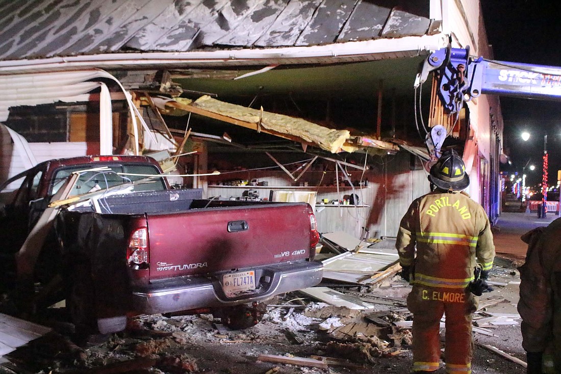 Portland firefighters and Barnett’s Wrecker Service stabilize and clear debris at T.J.’s Bicycle, Moped Sales and Service after Adam Hartvig, 40, Decatur, allegedly crashed his truck into the building at 7:36 p.m. Friday. Video footage from adjacent Portland Police Department showed a northbound truck swerving across lanes on Meridian Street (U.S. 27) before crashing into the side of the building owned by Tim Miller. Hartvig sustained minor injuries, and he was taken to IU Health Jay for further examination. Portland Police Chief Dustin Mock noted Friday the accident was under investigation but that authorities presumed alcohol to be a contributing factor in the accident. (The Commercial Review/Bailey Cline)