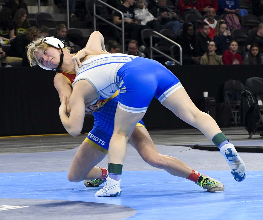 Brenna Ruble of the Jay County High School girls wrestling team throws No. 9 Vika Konovalenko of Columbus North in the IHSAA state finals 120-pound opener on Saturday at Corteva Coliseum. Ruble upset the opposing freshman by pinning her in 34 seconds to earn a spot on the podium. (The Commercial Review/Andrew Balko)