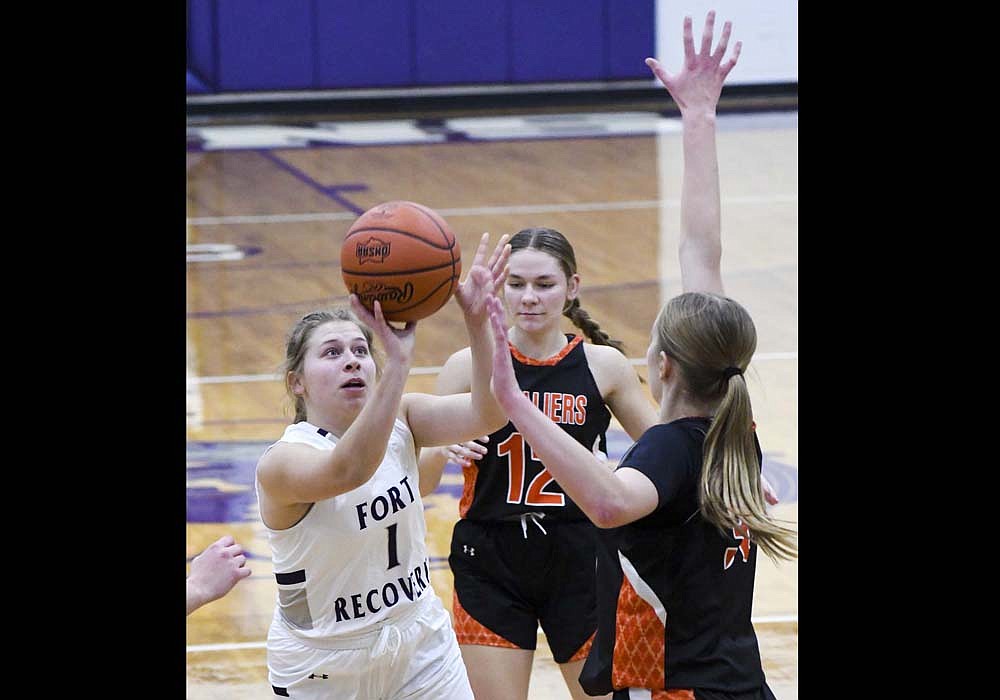 Paisley Hart of the Fort Recovery High School girls basketball team starts to shoot while Coldwater’s Harlow Heyne contests during the Tribe’s 51-43 victory on Thursday. (The Commercial Review/Andrew Balko)