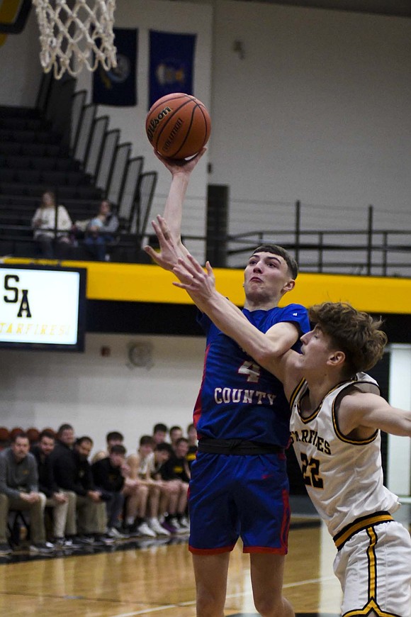 Jay County’s Jayden Comer gets fouled by Jackson Roe of South Adams on his way to the basket in Friday’s 49-45 win. Comer led the Patriots for the second straight game with 18 points. (The Commercial Review/Ray Cooney)