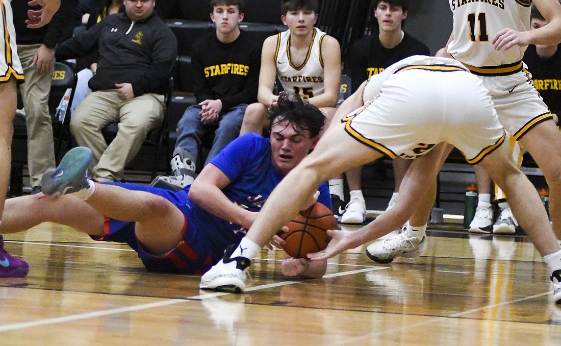 Aiden Phillips of the Jay County High School basketball team dives on the floor for a loose ball in the 49-45 win over South Adams on Friday. Phillips finished with four points in the win. (The Commercial Review/Andrew Balko)