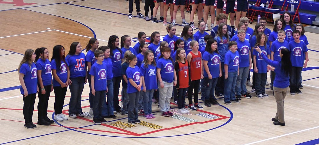 The Jay County elementary school choir performed The Star-Spangled Banner on Tuesday night before the Jay County High School girls basketball game against Heritage. It was part of a variety of activities for the evening, including free popcorn for fans, honoring the elementary and middle school girls basketball teams and a poster signing with the varsity squad after the game. For more on the JCHS win, see page 8. (The Commercial Review/Ray Cooney)