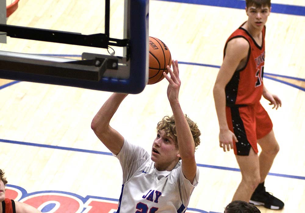 Jay County High School sophomore Eli Petro goes to the basket to finish after a spin move around Cameron Williams of Bluffton during the fourth quarter Friday. The hoop gave the host Patriots the lead, but the Tigers got a 3-pointer from Declan Grieser in the waning moments to escape with a 47-46 victory. (The Commercial Review/Ray Cooney)