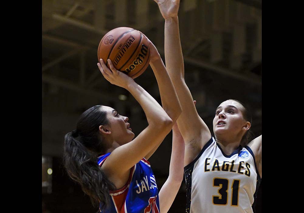 Natalie Carreno of the Jay County High School girls basketball team goes up for a 5-foot jump shot while Delta’s Jillian Barr prepares to block the attempt in the IHSAA Sectional 24 semifinal on Friday. Carreno scored eight points on offensive rebounds to help keep the Patriots close early, but the JCHS petered out before falling 59-38. (The Commercial Review/Andrew Balko)