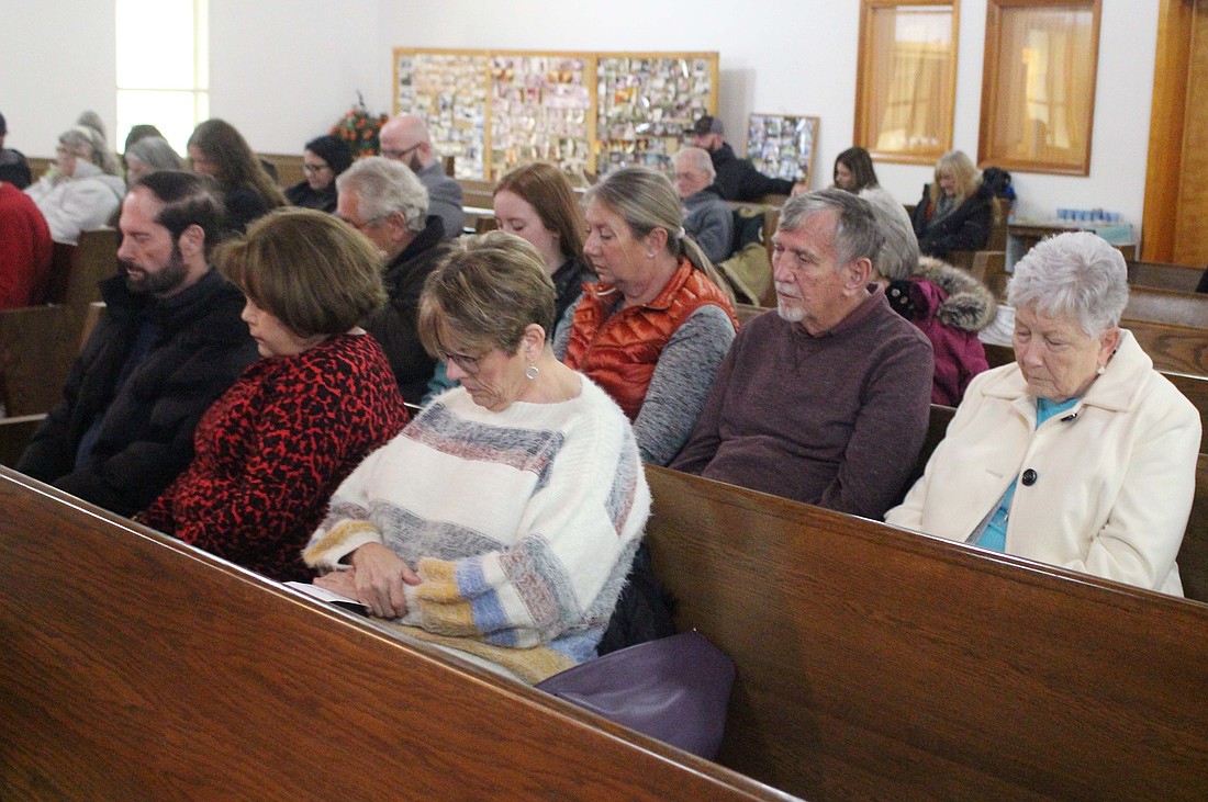 Past and present First American Baptist Church goers attended the church’s final service Jan. 19. Pictured above, churchgoers — including Pamela (Anderson) Frazee and Patty (Million) Walker in the front row — share a moment of prayer in the worship hall. (The Commercial Review/Bailey Cline)