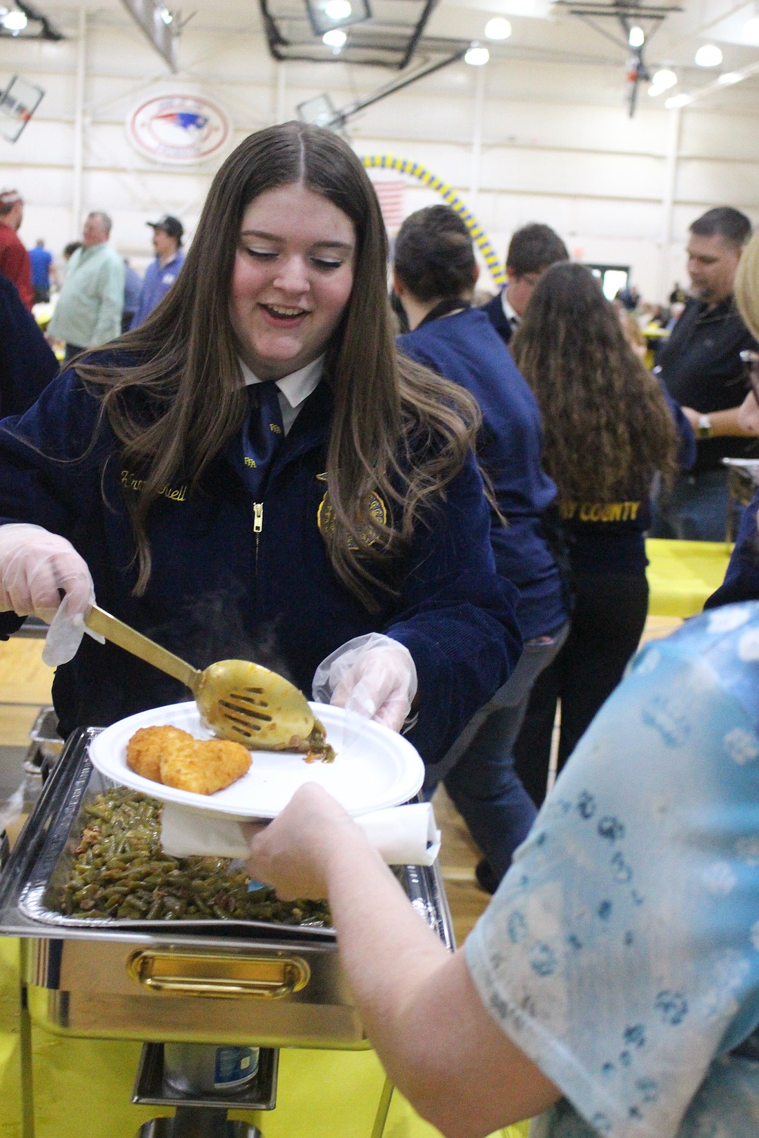 Hrmny Tuell puts food on a plate for a visitor to the Jay County FFA banquet on Friday in the auxiliary gym at Jay County Junior-Senior High School. (The Commercial Review/Bailey Cline)