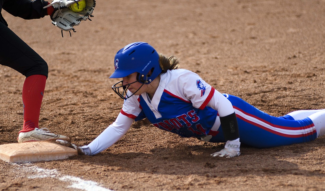 Natalie May, a courtesy runner for Jay County High School catcher Jaelynn Lykins, dives back into first base during the Patriots 10-0 win over Blackford on Monday. The Patriots will look to stay undefeated today as they take on sectional foe Delta. (The Commercial Review/Ray Cooney)