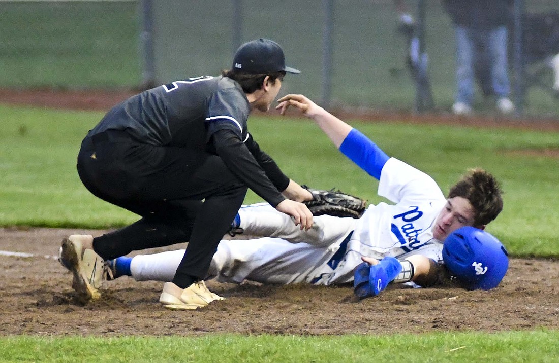 Leighton Brown of the Jay County High School baseball team dives back to first base safely during the Patriots’ season opener April 4 against Eastbrook. Brown had the team’s only hit in the 6-1 loss. (The Commercial Review/Andrew Balko)