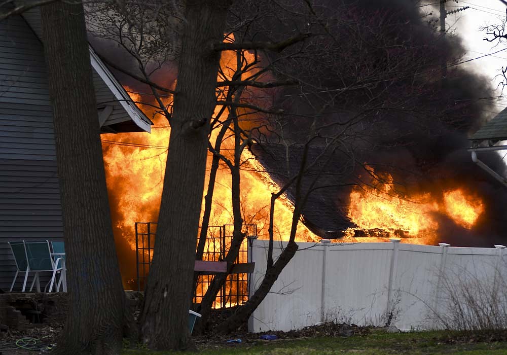 Flames engulf a garage north of a house at 412 E. Race St., Portland, on Sunday evening. Portland firefighters had the fire under control in about 15 minutes. No injuries were reported. (The Commercial Review/Ray Cooney)
