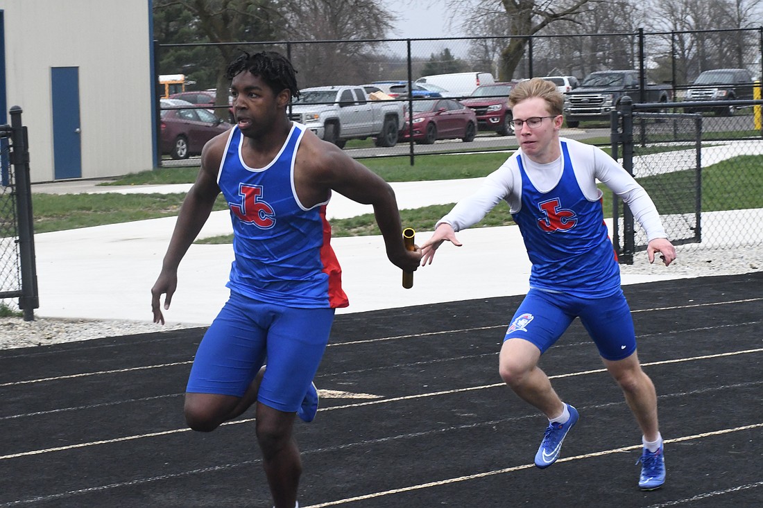 Jay County High School’s Gabe Pinkerton hands the baton off to Caden Gambill during the 4x100-meter relay in Thursday’s track meet with Delta and Yorktown. The Patriots finished third in the event with a time of 45.55 seconds. (The Commercial Review/Andrew Balko)