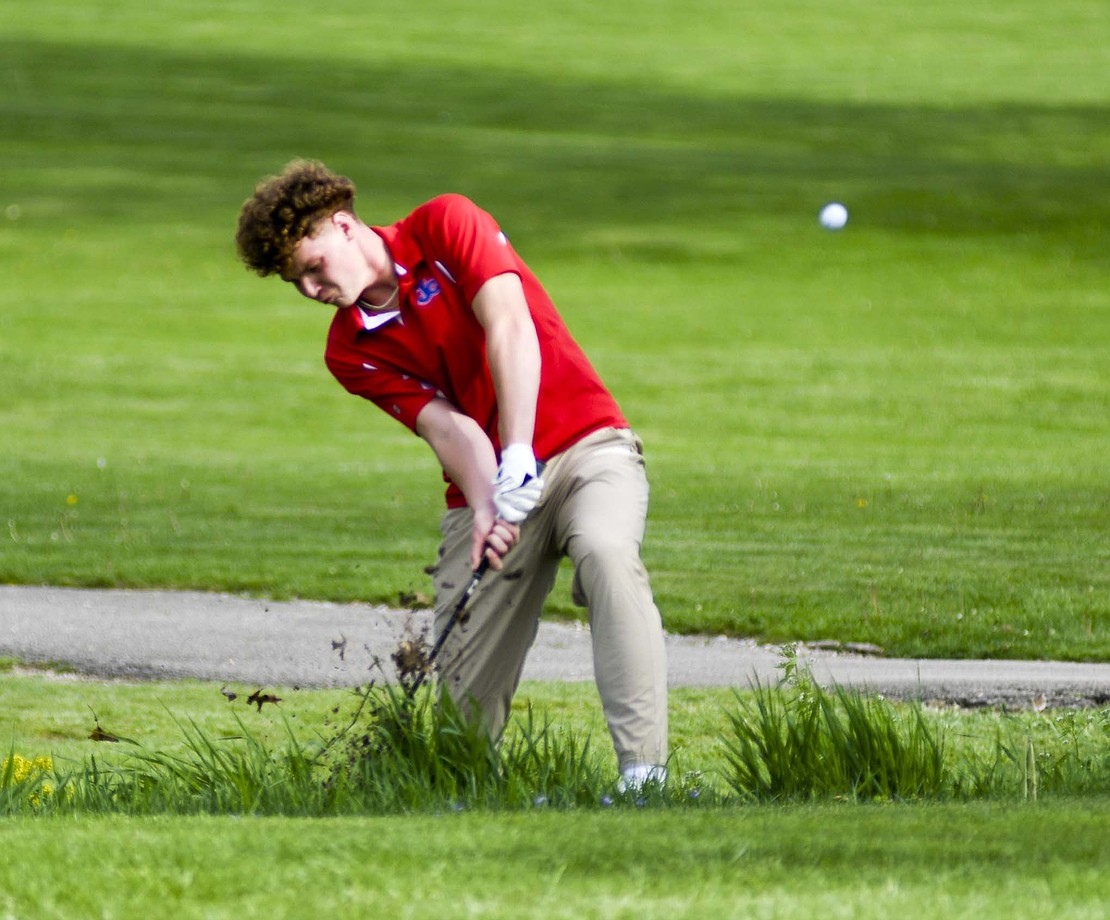 Jay County High School senior Tucker Griffin hits out of some weeds above the creek during Thursday’s match against Blackford on Portland Golf Club’s first hole. Despite his drive sailing to the left, he saved himself for a bogey en route to a round of 42 that earned match medalist honors and push JCHS to a 173-209 victory. (The Commercial Review/Andrew Balko)
