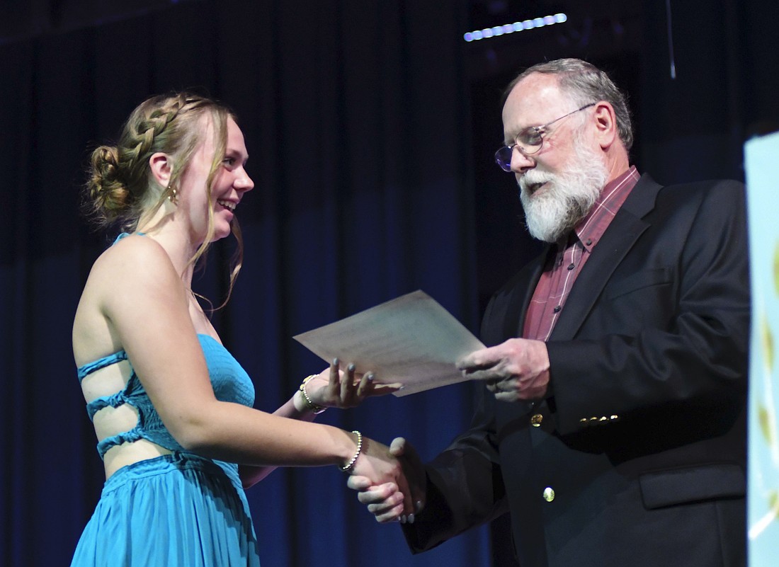 Jesse Bivens presents a scholarship to senior Morgan DeHoff during Honors Night on Monday at Jay County Junior-Senior High School. (The Commercial Review/Ray Cooney)