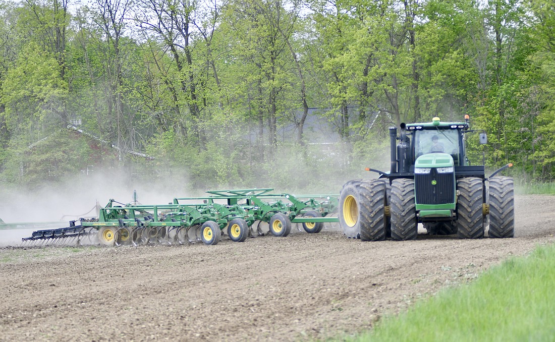 A farmer makes a turn in his tractor while working a field Monday morning on the south side of county road 350 South, just east of county road 200 West. A wet spring slowed the start of the planting season, but farmers got a lot of work done over the weekend with warm and sunny conditions. Rain is expected to return Tuesday, with more precipitation possible Wednesday. (The Commercial Review/Ray Cooney)