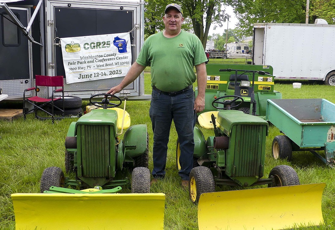 Mike Watson, 54, from Hemlock, Michigan, poses next to a portion of his display during the Tri State Tractor and Engine Association's Spring Swap and Sell Meet on May 14, 2025, in Portland, Indiana. Watson has been attending the show for 25 years. In addition to these two John Deere snowmobiles, he has 40 more John Deere vehicles back home. (The Commercial Review/Lindy Mercer)